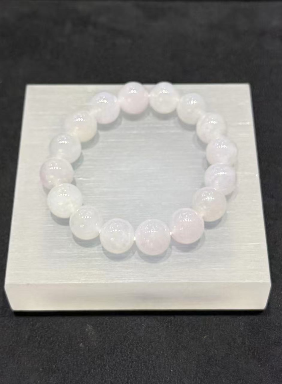 Lavender jade bracelet strung with round icy translucent jadeite beads in a whiteish body with a very faint lavender tint