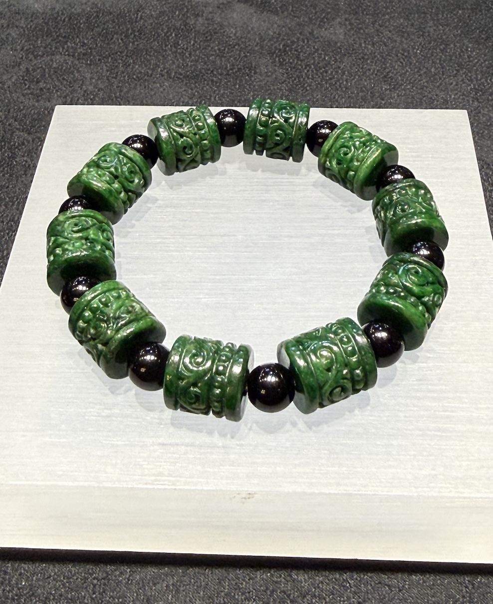 translucent dark green Ruyi jadeite bracelet with carved beads and black bead accents