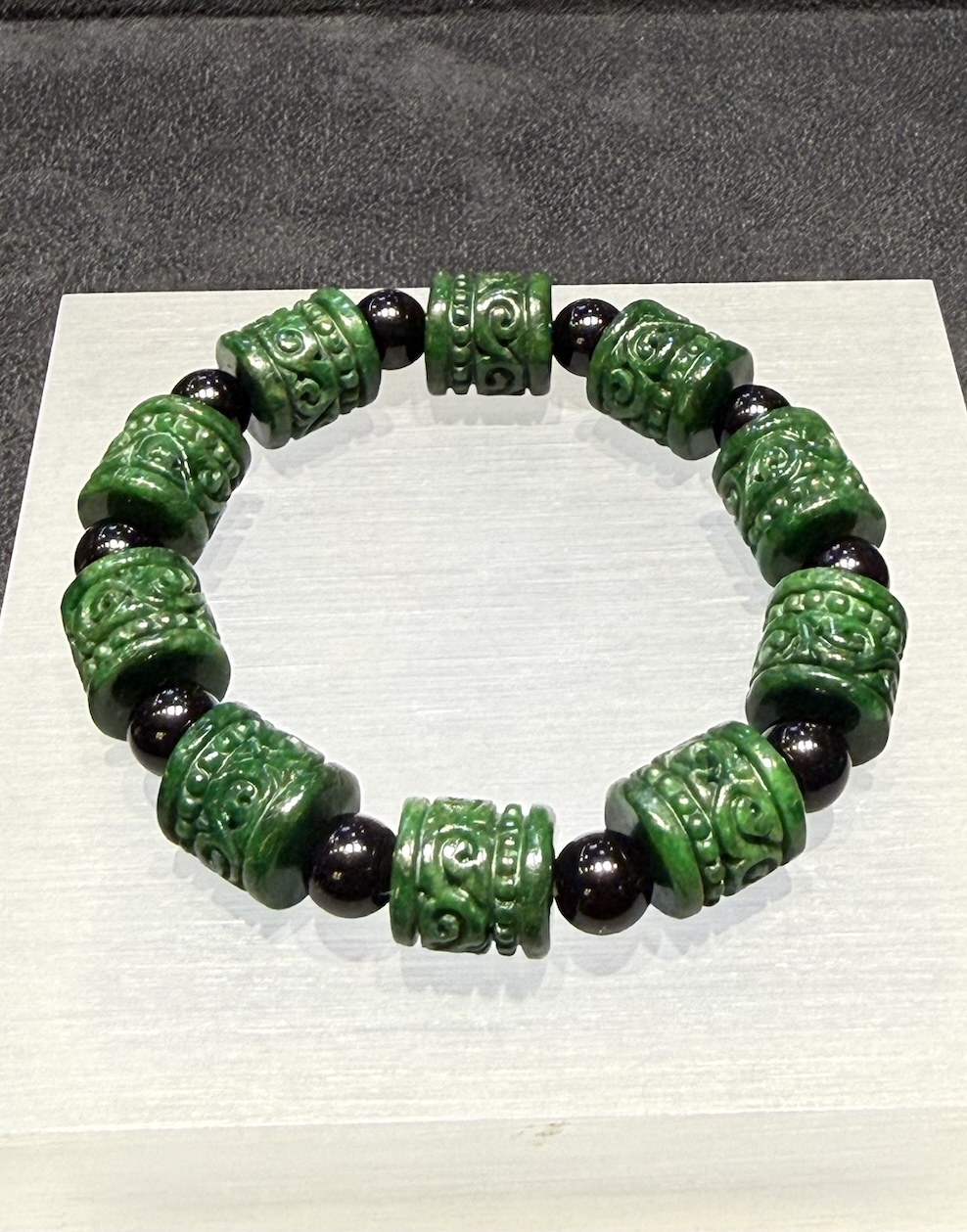 translucent dark green Ruyi jadeite bracelet with carved beads and black bead accents