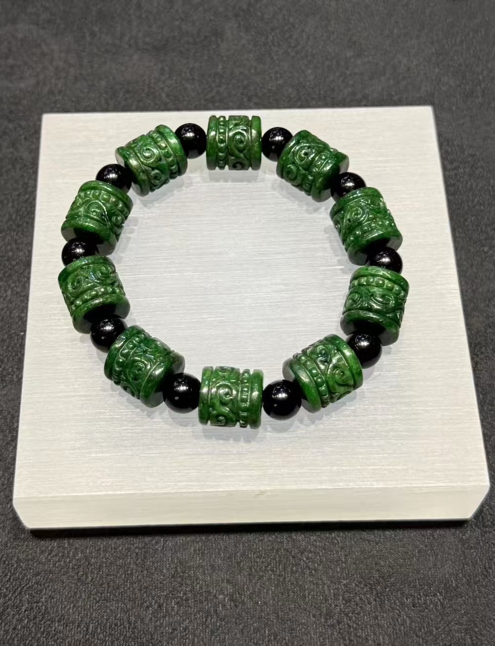 translucent dark green Ruyi jadeite bracelet with carved beads and black bead accents