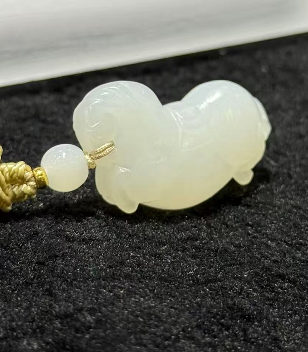 Jade horse pendant hand-carved from creamy white nephrite in the traditional Chinese Tang horse (唐马) style, hung from a small braided cord with a jade bead
