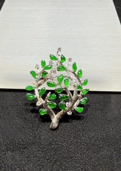 Jade tree brooch pendant with highly translucent vibrant green jadeite leaves on textured 18k white gold branches, set with small diamond accents, designed as a longevity tree