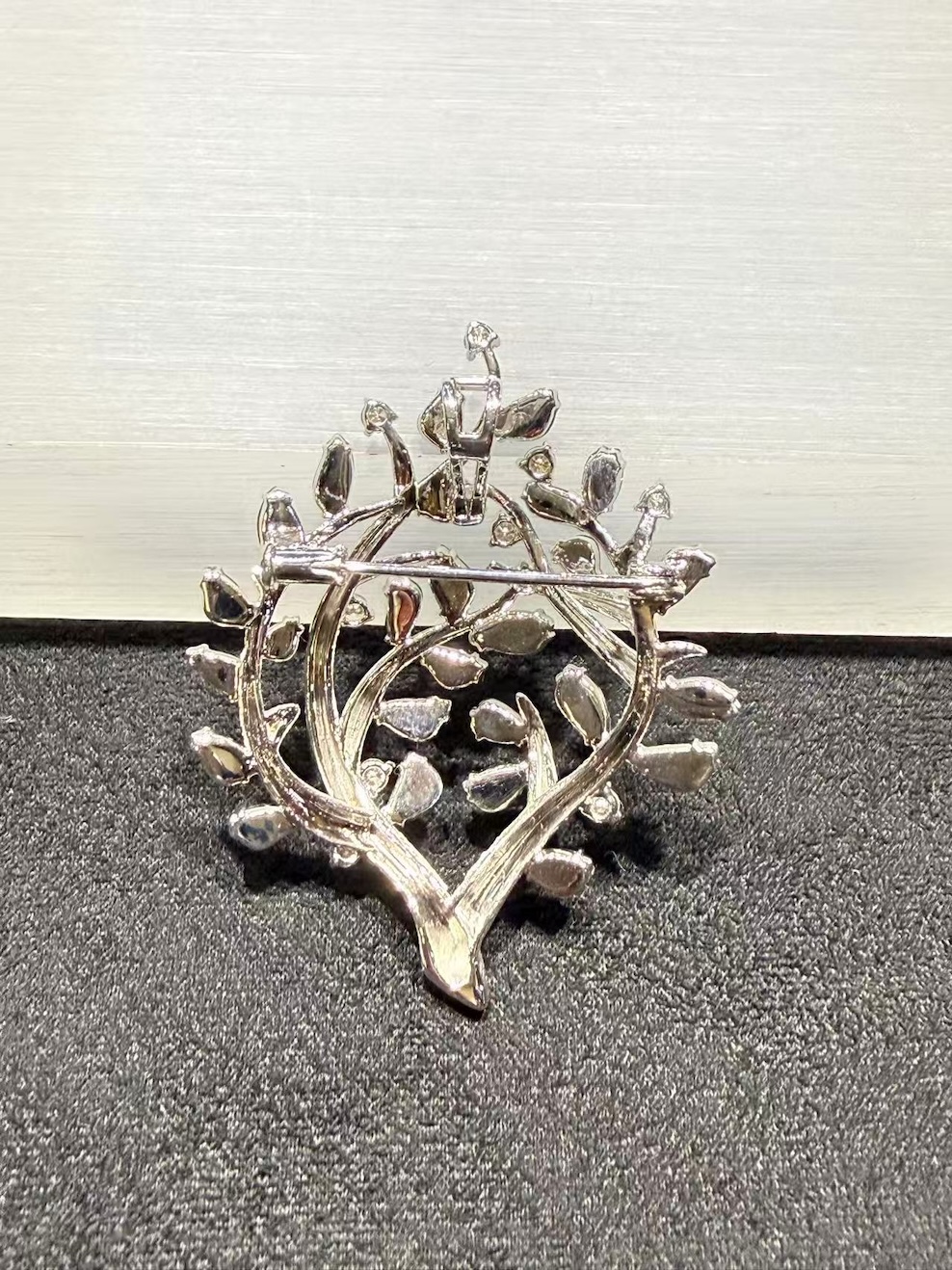 Jade tree brooch pendant with highly translucent vibrant green jadeite leaves on textured 18k white gold branches, set with small diamond accents, designed as a longevity tree