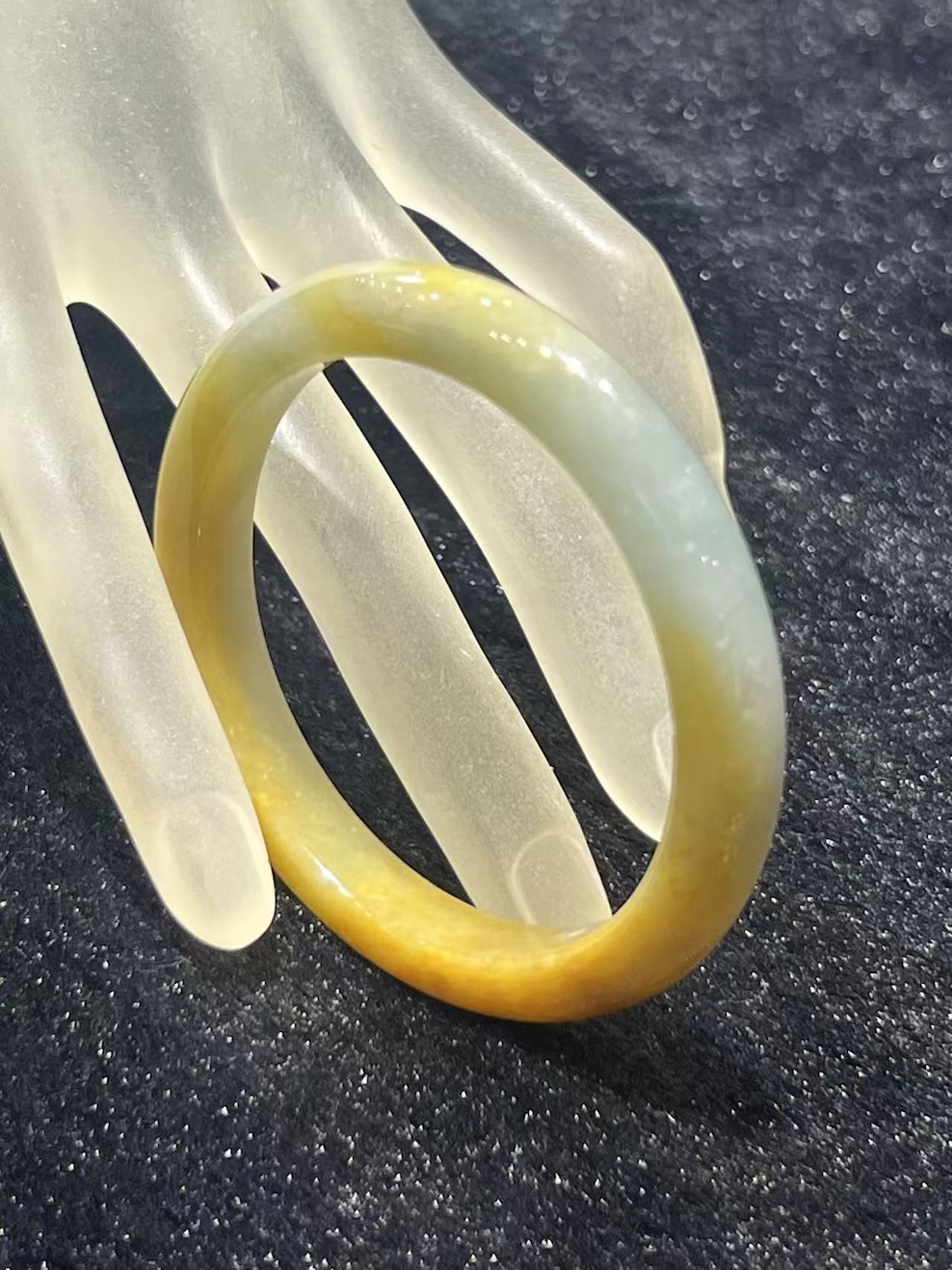 Honey jade bangle in a translucent, warm honey-yellow jadeite with a lighter near-colourless section near the top of the ring