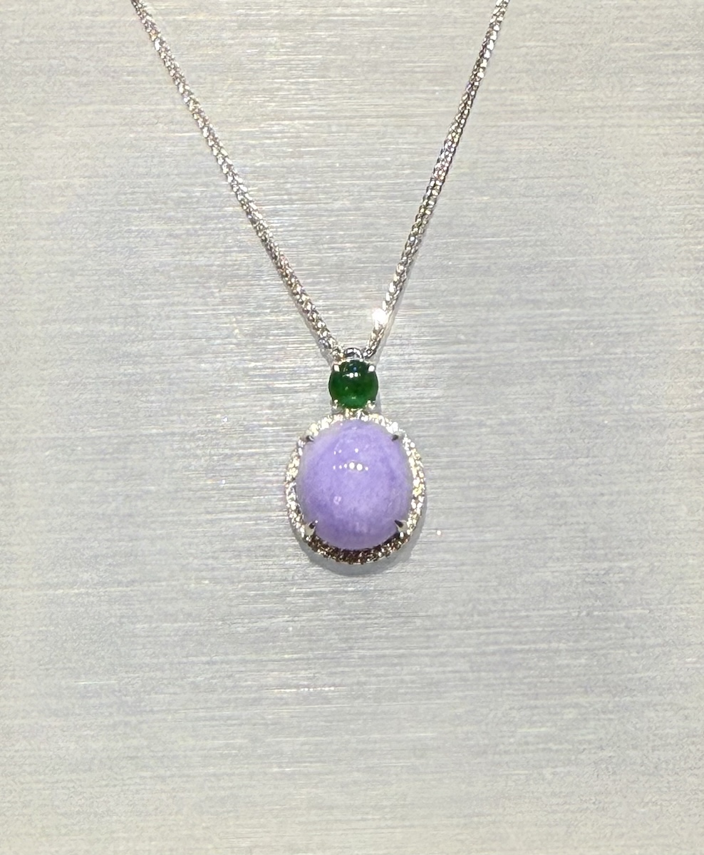 Lavender jade cabochon pendant with a translucent lavender jadeite centre framed by a diamond halo in 18k white gold, and a small vibrant green jadeite cabochon above