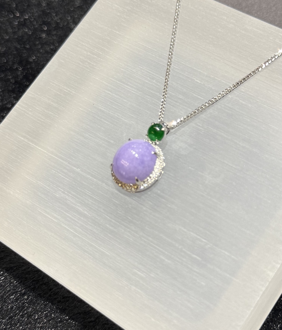 Lavender jade cabochon pendant with a translucent lavender jadeite centre framed by a diamond halo in 18k white gold, and a small vibrant green jadeite cabochon above