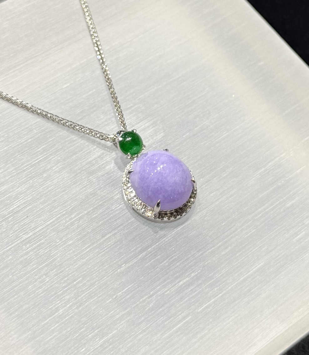 Lavender jade cabochon pendant with a translucent lavender jadeite centre framed by a diamond halo in 18k white gold, and a small vibrant green jadeite cabochon above