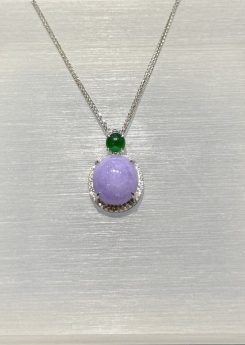 Lavender jade cabochon pendant with a translucent lavender jadeite centre framed by a diamond halo in 18k white gold, and a small vibrant green jadeite cabochon above