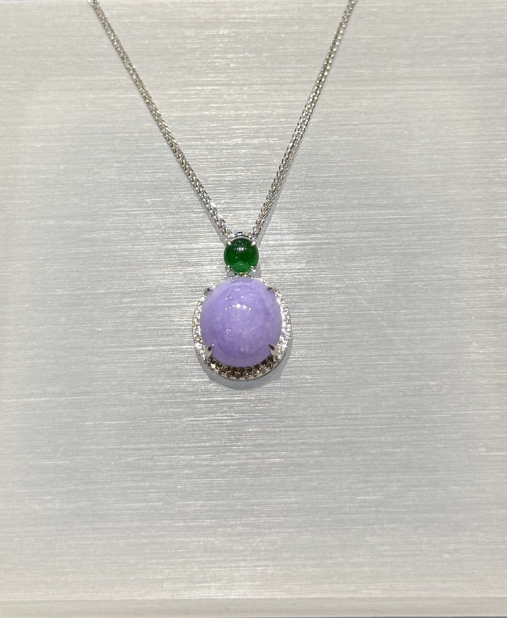 Lavender jade cabochon pendant with a translucent lavender jadeite centre framed by a diamond halo in 18k white gold, and a small vibrant green jadeite cabochon above