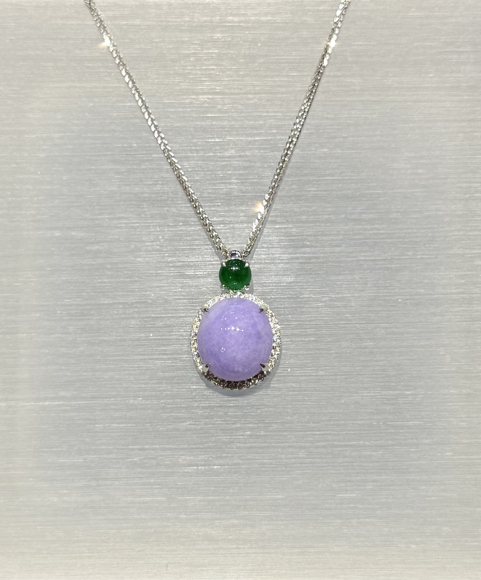 Lavender jade cabochon pendant with a translucent lavender jadeite centre framed by a diamond halo in 18k white gold, and a small vibrant green jadeite cabochon above