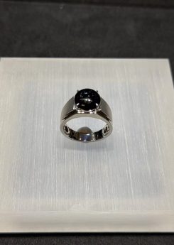 Omphacite jade ring with a translucent black mo cui cabochon that reads pure black under normal light and glows translucent green under torchlight, set in a wide 18k white gold band