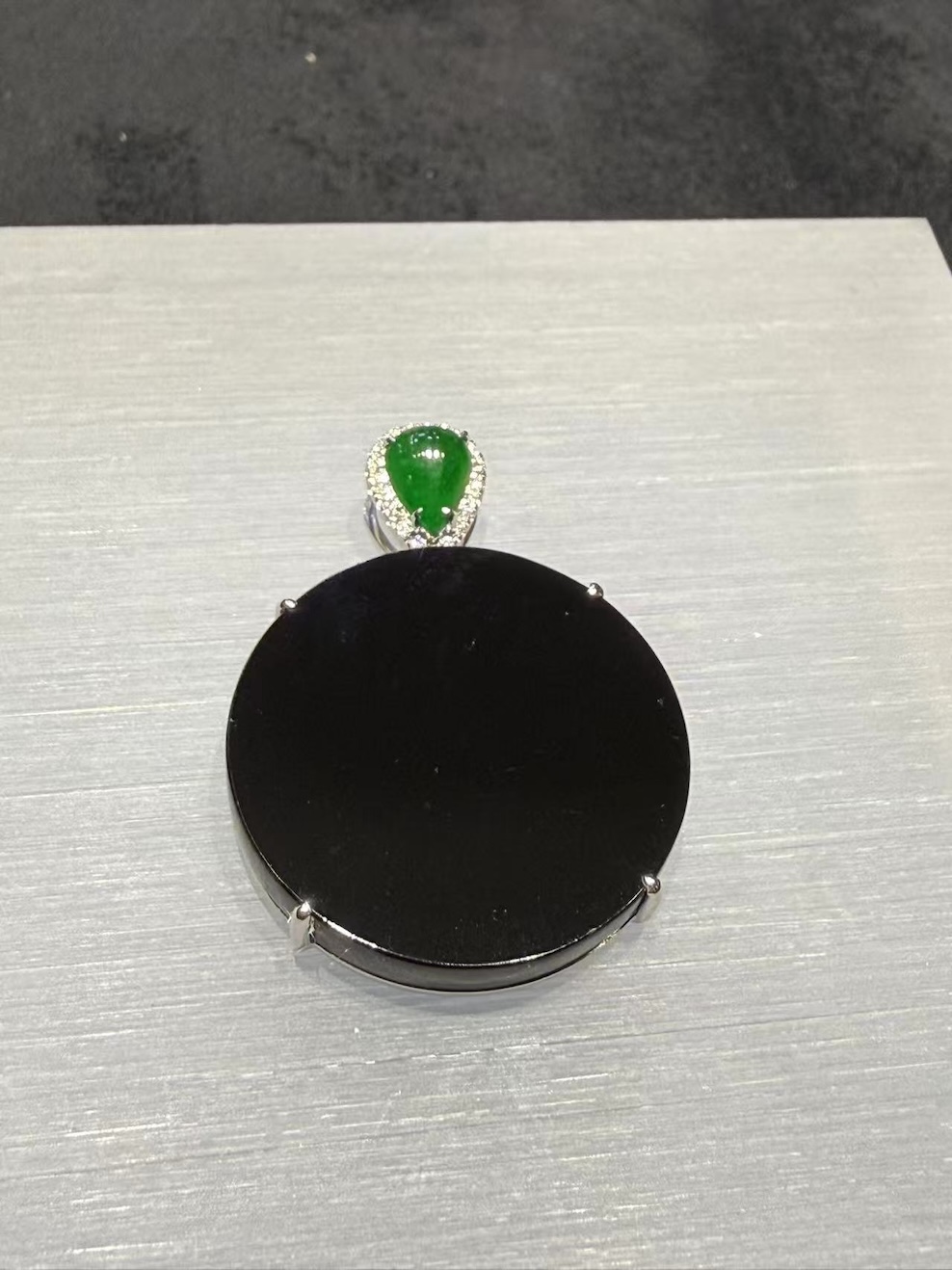 Omphacite jade ring with a translucent black mo cui cabochon that reads pure black under normal light and glows translucent green under torchlight, set in a wide 18k white gold band